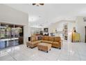Spacious open-plan living area featuring vaulted ceilings, tile floors, and a comfortable leather sectional sofa at 4856 Jacaranda Heights Dr, Venice, FL 34293