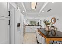 Bright kitchen with white cabinets, stainless steel appliances, tile floors and a view into the living area at 5031 N Beach Rd # 118, Englewood, FL 34223