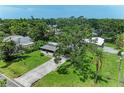 Aerial view of a modest home with a spacious lawn and mature trees surrounding the property at 5106 S Lockwood Ridge Rd, Sarasota, FL 34231