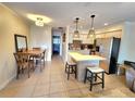 Inviting kitchen with stainless steel appliances, barstool seating, and tiled floors at 525 Manatee Ct # 13, Venice, FL 34285