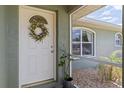Inviting front entrance featuring a decorative wreath and cozy screened-in porch at 5264 Albion Rd, Venice, FL 34293