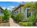 Charming walkway lined with lush plants and lighting leads to the front of this beautifully landscaped home at 5856 Semolino St, Nokomis, FL 34275