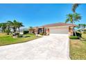 Inviting exterior showcases lush landscaping, mature palms, and a wide driveway leading to the two-car garage at 5868 Jefferson Rd, Venice, FL 34293