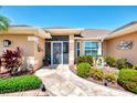 Inviting front entrance featuring a decorative walkway, charming landscaping, and stylish screen door at 5868 Jefferson Rd, Venice, FL 34293