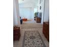 Inviting living room with neutral carpeting, vertical blinds, and comfortable seating at 603 Auburn Lakes Cir # 603, Venice, FL 34292
