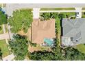 An aerial view shows the house with a brown roof and screened in pool, surrounded by lush landscaping at 622 Pine Ranch East Rd, Osprey, FL 34229