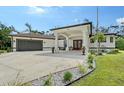 Front exterior of a white, single-story house with a two-car garage and covered entrance at 66 Statler St, Port Charlotte, FL 33954