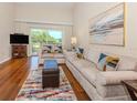 Comfortable living room with wood floors, neutral furniture, and outdoor views at 770 Village Cir # 232, Venice, FL 34292