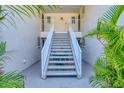Welcoming condo entrance with staircase leading to upper units, surrounded by lush tropical landscaping at 819 Montrose Dr # 102, Venice, FL 34293