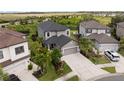 An aerial view captures this home with a well-manicured yard, lush landscaping, and neutral color palette at 8304 Shooting Star Rd, Sarasota, FL 34241