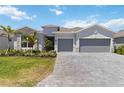 Charming single-story home with a well manicured lawn, stone accents, and a three-car garage at 8529 Saint Kitts Cir, Englewood, FL 34224