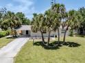 Inviting home with a carport and mature palm trees enhancing the curb appeal at 929 Cypress Ave, Venice, FL 34285