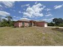 A ranch style home with a beautiful lawn and landscaping at 98 Maltby St, Port Charlotte, FL 33953