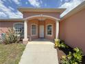 A covered front entryway with decorative columns and a well manicured front yard at 98 Maltby St, Port Charlotte, FL 33953
