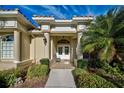 Inviting front entrance with double doors, decorative columns, and manicured landscaping enhancing the curb appeal of this lovely home at 1037 Beckley Cir, Venice, FL 34292