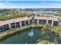Aerial view of the condo community showcasing a tranquil pond and surrounding lush greenery at 1156 Bird Bay Way # 104, Venice, FL 34285