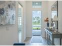 Bright foyer with a decorative table, wood-look tile flooring, and an inviting front door at 12548 Wellen Golf St, Venice, FL 34293