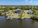 Expansive estate on the water, featuring mature palms, boat lift, detached garage, and screened-in lanai at 13314 Prentice Ave, Port Charlotte, FL 33953
