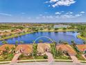 Beautiful home aerial shot with mature landscaping and a lake view, complete with tile roof at 138 Rimini Way, North Venice, FL 34275