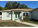 Inviting front exterior showcasing a walkway leading to the covered entrance with glass double doors at 1483 Prairie Ter, North Port, FL 34286