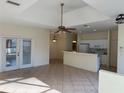 Bright, open-concept living space with tile flooring, neutral walls, and access to the kitchen at 1483 Prairie Ter, North Port, FL 34286