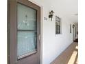 Exterior entrance to Unit 212 featuring a brick floor, light fixtures, and a brown door at 1730 Manasota Beach Rd # 212, Englewood, FL 34223