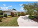Beautiful single story home featuring a circular driveway, lush landscaping, and a well maintained lawn at 1833 Raintree Ln, Venice, FL 34293