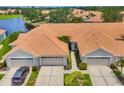 Clean aerial shot of these light-colored homes with a lake view in the neighborhood at 1892 San Silvestro Dr, Venice, FL 34285