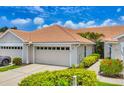 Beautiful exterior view of the home's garage, landscaping, and long driveway at 1892 San Silvestro Dr, Venice, FL 34285