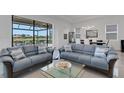 Bright living room featuring stylish furnishings and expansive windows with lake views at 19337 Cruise Dr, Venice, FL 34292
