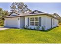 Charming single-story home showcasing lush green lawn, well-kept landscaping, and impeccable curb appeal at 2032 Jagust Rd, North Port, FL 34288