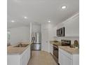 Well-lit kitchen featuring stainless steel appliances, sleek countertops, and abundant storage space at 2032 Jagust Rd, North Port, FL 34288