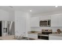 Bright kitchen featuring stainless steel appliances, sleek countertops, and ample storage at 2032 Jagust Rd, North Port, FL 34288