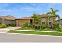 Beautiful home with lush tropical landscaping, paver driveway, and a terracotta roof at 20660 Ovid Ln, Venice, FL 34293