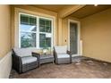Cozy front porch with comfortable seating and a welcoming entrance at 20660 Ovid Ln, Venice, FL 34293