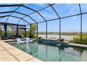 Screened-in pool area overlooking a lake, complete with outdoor seating and space for lounging at 20660 Ovid Ln, Venice, FL 34293