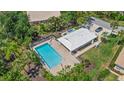 Aerial view of community pool surrounded by lush greenery and lounging area at 2092 Timucua Trl, Nokomis, FL 34275