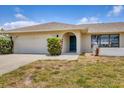 View of the exterior showcases the two car garage and the charming archway entrance at 2311 Sandlewood Dr, Venice, FL 34293