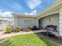 Close-up of an inviting home entrance with bench and manicured landscaping, perfect for relaxing outdoors at 232 Cerromar Way # 38, Venice, FL 34293
