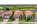 An aerial view showcases this charming single-story house with a lush backyard overlooking a serene pond at 23493 Copperleaf Dr, Venice, FL 34293