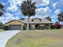 Charming single-story home with a well-manicured lawn and a palm tree in the front yard at 236 Cory St, Port Charlotte, FL 33953