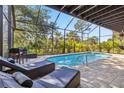 Enclosed pool with brick pavers, lounge chairs, and view of lush landscaping at 236 Cory St, Port Charlotte, FL 33953