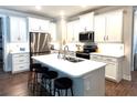 A kitchen with white cabinets, stainless steel appliances, and a large island with seating at 236 Soliera St, Nokomis, FL 34275