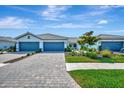 Attractive single-story home with well-manicured landscaping, brick paved driveway, and a welcoming facade at 25069 Pearl Lake Cir, Englewood, FL 34223