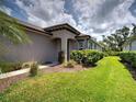 Landscaped front yard featuring lush greenery and colorful flowering shrubs at 25784 Grayton Ave, Englewood, FL 34223