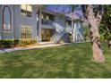 Low angle of a condo with green lawn and landscaping, showing walkways and staircases at 2614 River Preserve Ct # 2614, Bradenton, FL 34208