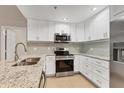 Bright kitchen with white cabinets, granite countertops, stainless steel appliances, and a modern backsplash at 2614 River Preserve Ct # 2614, Bradenton, FL 34208