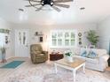 Bright living room featuring a comfortable sofa, armchair, and a large window at 30 Jamestown Ave, Englewood, FL 34223