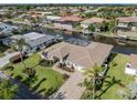 An aerial view shows a waterfront home with lush landscaping, a paver driveway, and a screened-in pool at 314 Oakwood Cir, Englewood, FL 34223