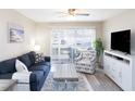 Cozy living room featuring a comfortable sofa, armchair, and sliding glass doors at 3255 Beneva Rd # 102, Sarasota, FL 34232